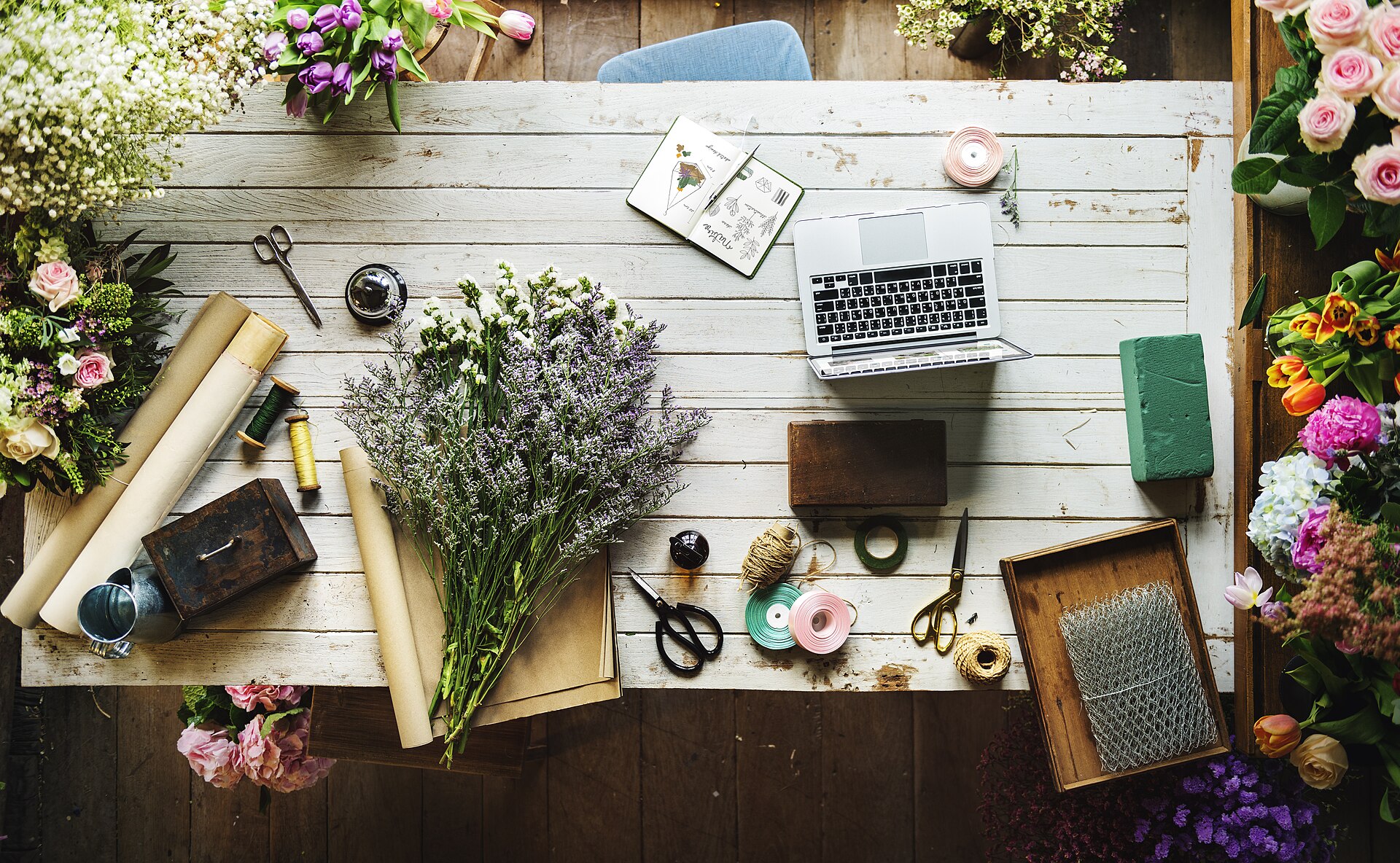Florist's worktable with flowers, ribbon and packing materials